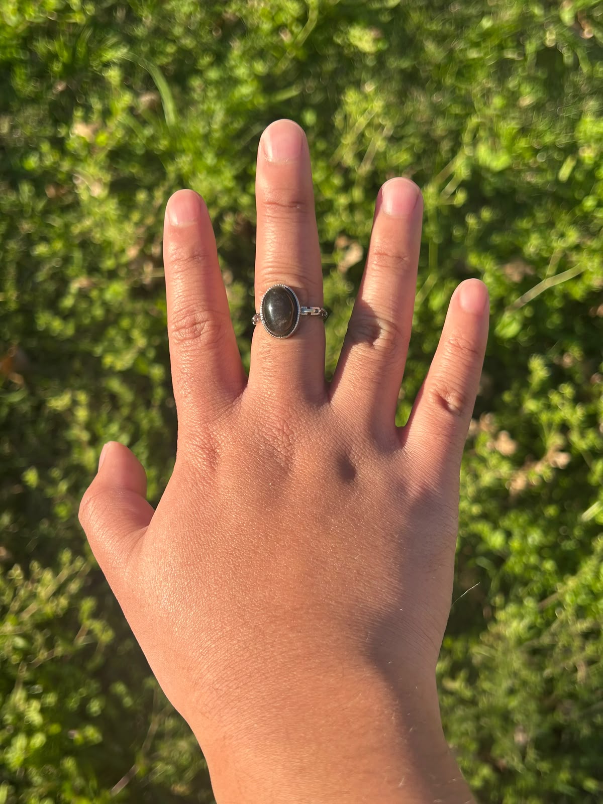 Anillo Medianoche Plateada KLORE con obsidiana plateada natural puesto en la mano